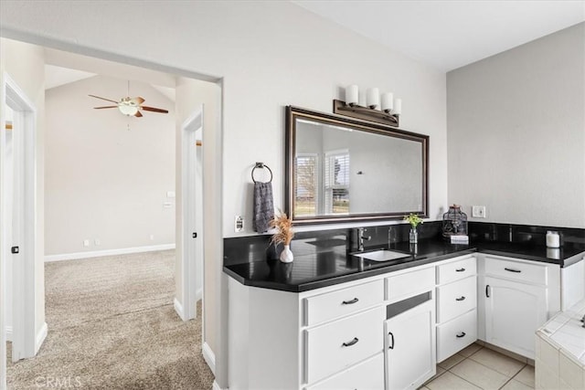 kitchen with white cabinets, lofted ceiling, light carpet, sink, and ceiling fan