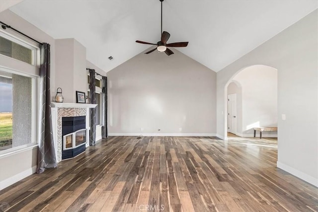 unfurnished living room with ceiling fan, dark hardwood / wood-style flooring, high vaulted ceiling, and a fireplace