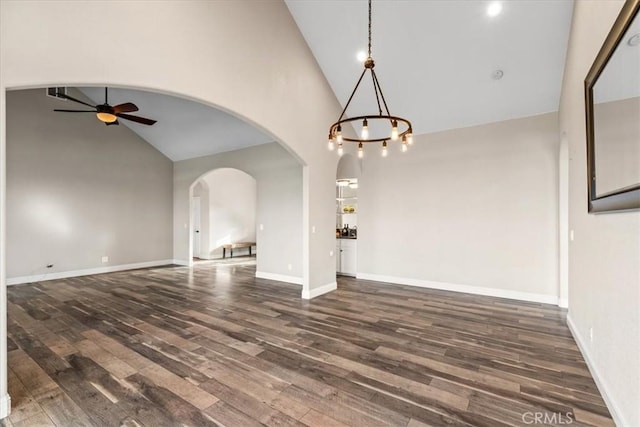 interior space with high vaulted ceiling, dark hardwood / wood-style floors, and ceiling fan with notable chandelier