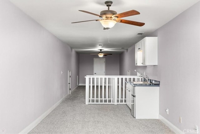 hallway with light colored carpet and sink