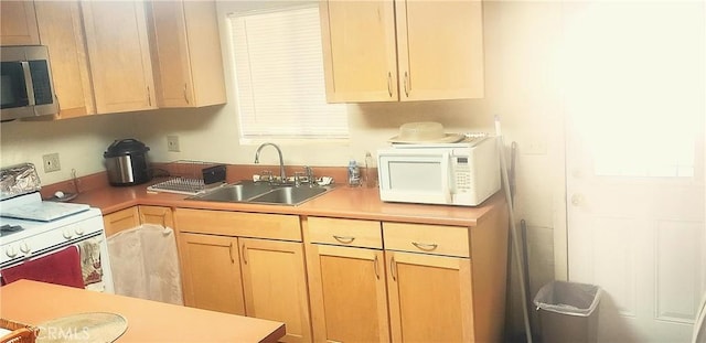 kitchen featuring light brown cabinets, sink, and white appliances