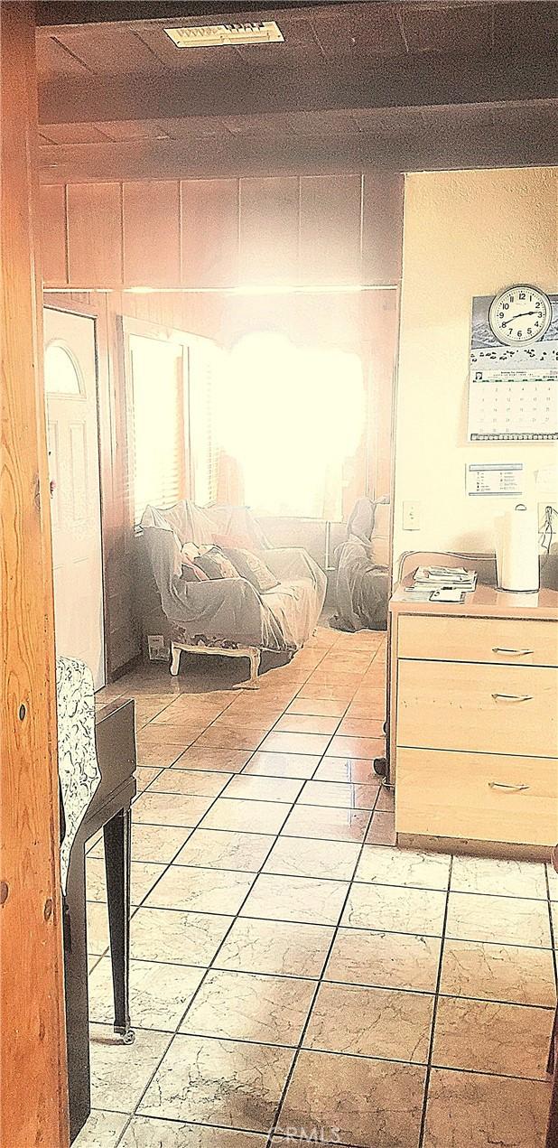 bedroom with tile patterned floors and wood walls