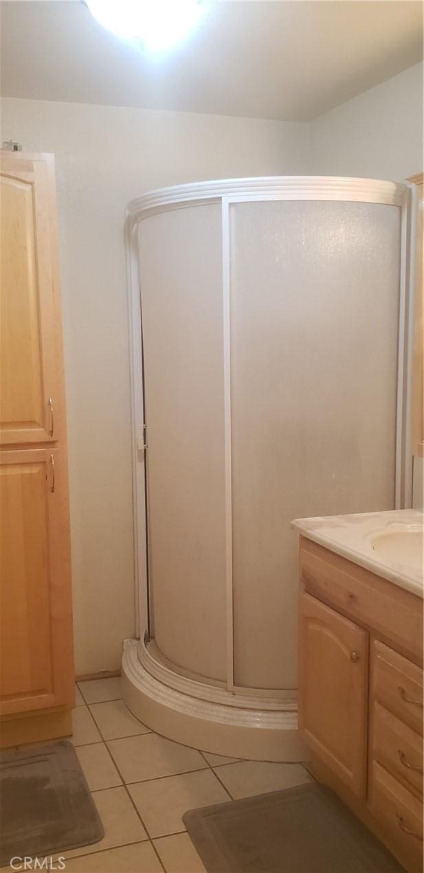 bathroom with vanity, tile patterned flooring, and walk in shower