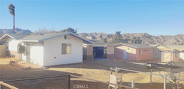 view of front of property with a shed and a mountain view