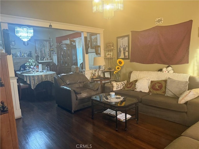 living room with dark wood-type flooring and a notable chandelier