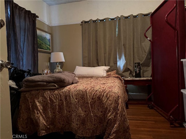 bedroom with dark hardwood / wood-style floors