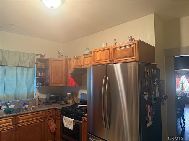 kitchen with appliances with stainless steel finishes, sink, and dark stone counters