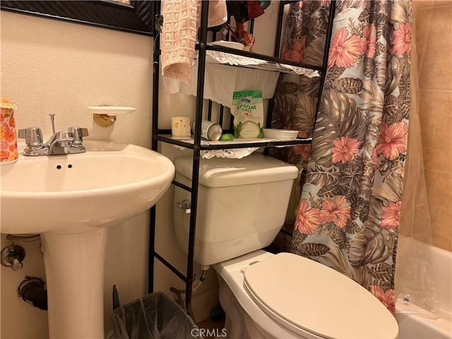 full bathroom with sink, toilet, and shower / tub combo with curtain