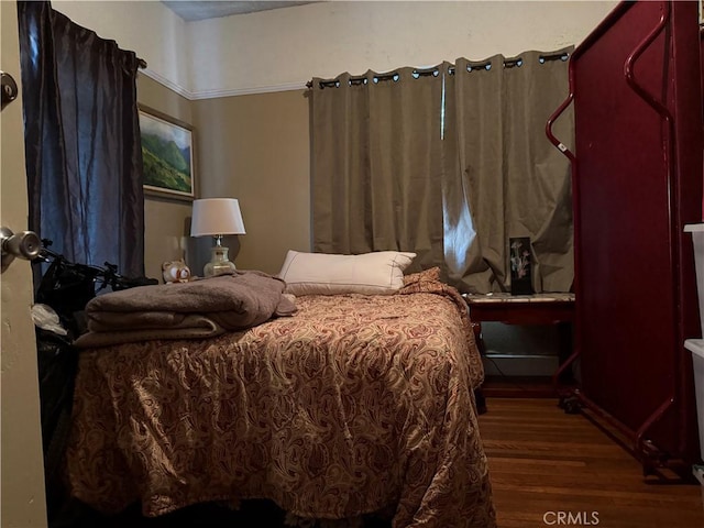 bedroom with dark hardwood / wood-style flooring