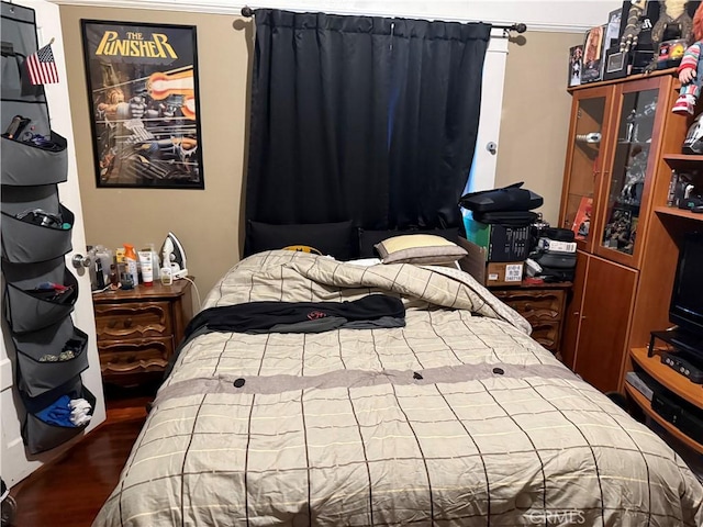 bedroom with dark hardwood / wood-style flooring