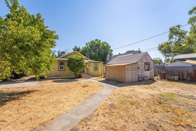 view of front of home with a front yard and a shed