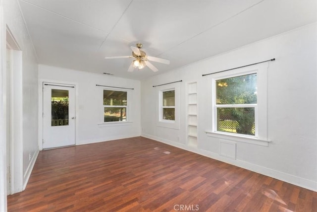 empty room featuring ceiling fan, built in features, and dark hardwood / wood-style flooring