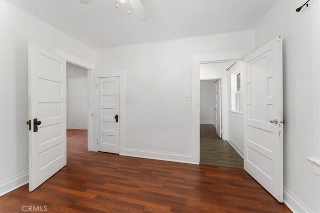 unfurnished bedroom featuring ceiling fan and dark wood-type flooring