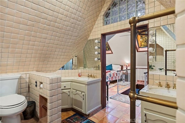 bathroom with tile walls, vanity, and tile patterned flooring