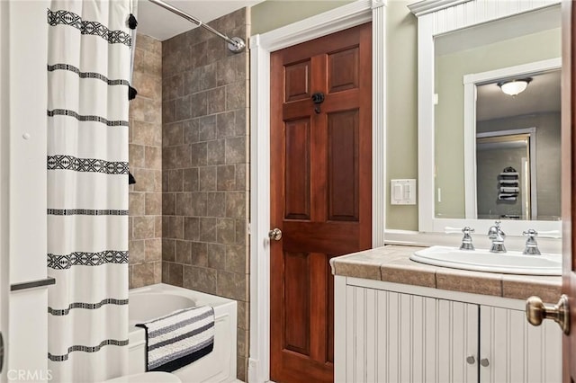 bathroom featuring vanity and shower / bathtub combination with curtain