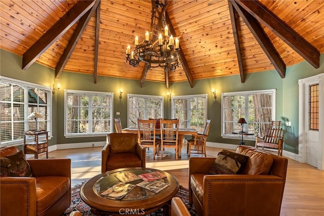 living area with baseboards, beam ceiling, a chandelier, and a wealth of natural light