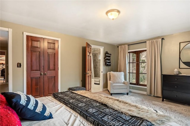 carpeted bedroom featuring ensuite bathroom and a closet