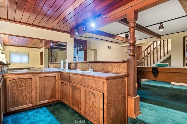 kitchen with kitchen peninsula, wood ceiling, sink, and dark carpet