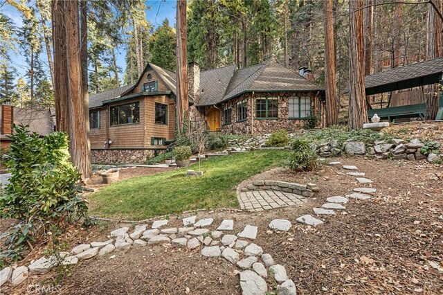 801 Kuffel Canyon Rd, Lake Arrowhead, CA 92385 - view of front facade featuring stone siding, a chimney, a front yard, and roof with shingles