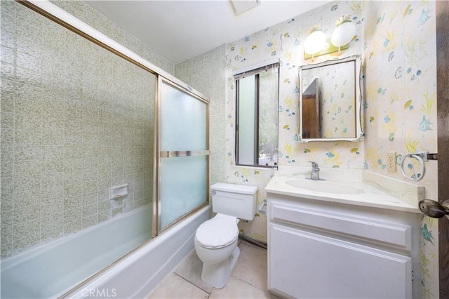 full bathroom featuring toilet, vanity, combined bath / shower with glass door, and tile patterned flooring