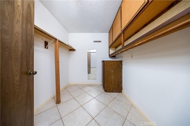 walk in closet with light tile patterned floors