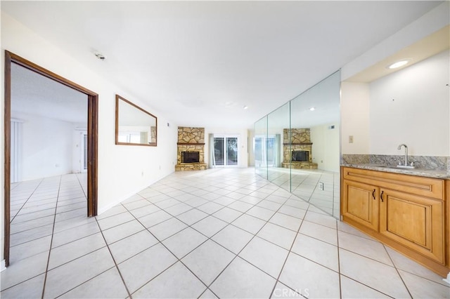 unfurnished living room featuring light tile patterned floors, a fireplace, and sink