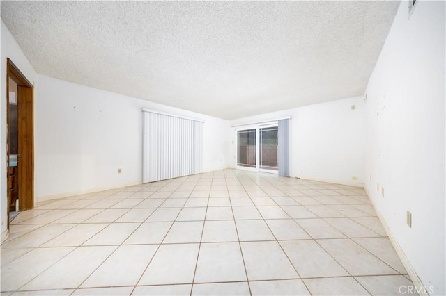 tiled spare room with a textured ceiling