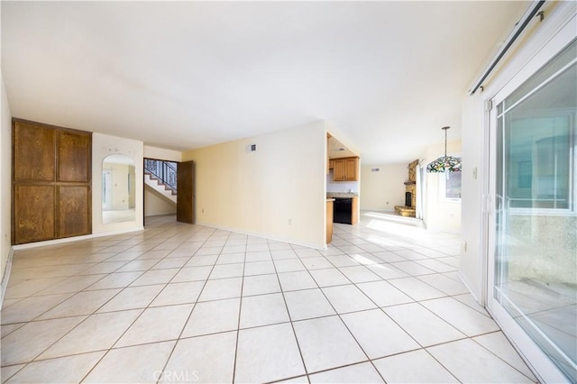 tiled empty room featuring an inviting chandelier