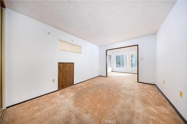 carpeted spare room featuring a textured ceiling