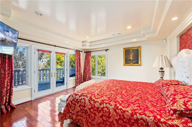 bedroom featuring hardwood / wood-style flooring, french doors, access to exterior, and a raised ceiling