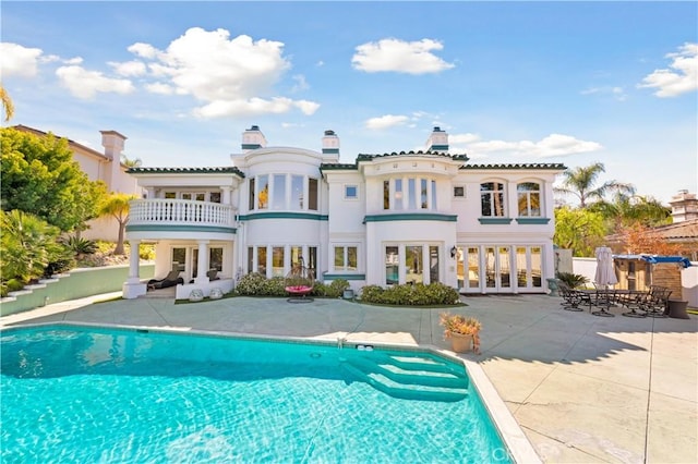 back of property featuring a balcony, a patio, and french doors