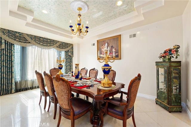 tiled dining space with a tray ceiling and an inviting chandelier