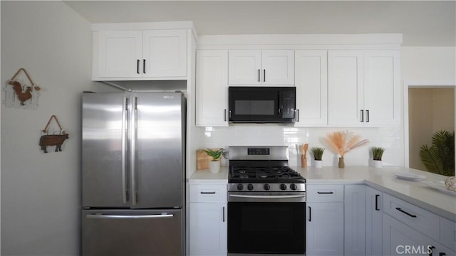 kitchen with white cabinetry, stainless steel appliances, and tasteful backsplash