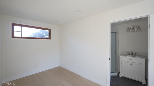 unfurnished room with hardwood / wood-style flooring and sink