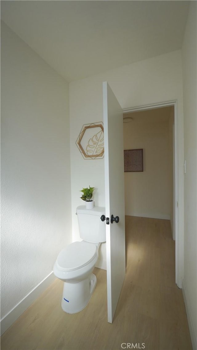 bathroom with toilet and hardwood / wood-style flooring