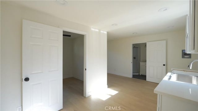 kitchen featuring white cabinets, light hardwood / wood-style flooring, and sink