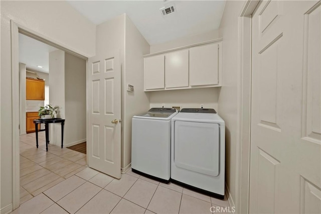 laundry area featuring light tile patterned flooring, independent washer and dryer, and cabinets