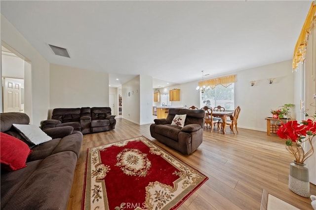 living room featuring wood-type flooring and an inviting chandelier