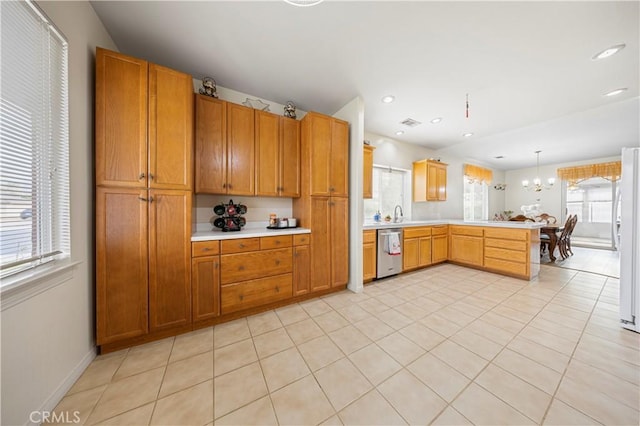 kitchen with decorative light fixtures, white fridge, stainless steel dishwasher, kitchen peninsula, and light tile patterned floors