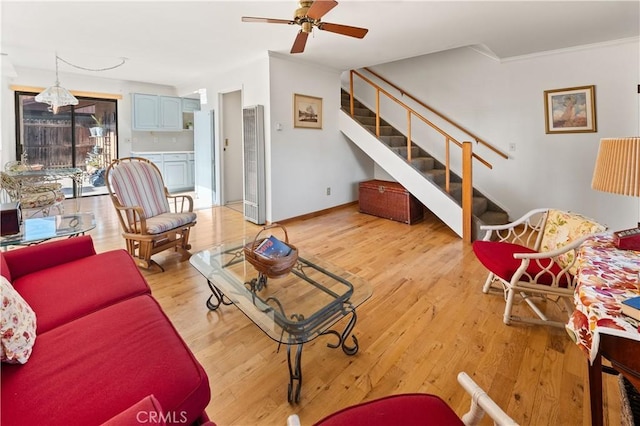 living room with crown molding, ceiling fan, and light hardwood / wood-style flooring