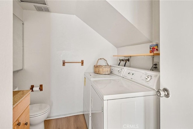 washroom with wood-type flooring and washing machine and dryer