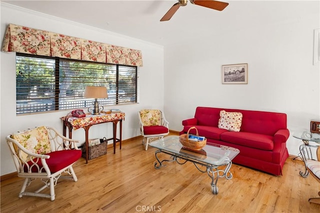 living room featuring ceiling fan, ornamental molding, and wood-type flooring