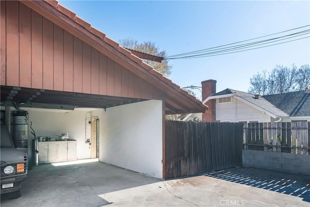 view of property exterior featuring water heater and a carport