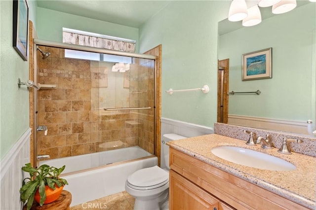 full bathroom with vanity, bath / shower combo with glass door, tile patterned floors, and toilet