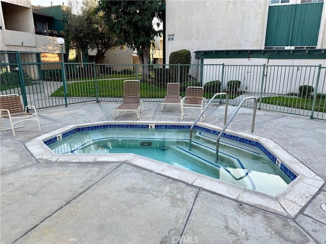 view of swimming pool featuring a community hot tub and a patio