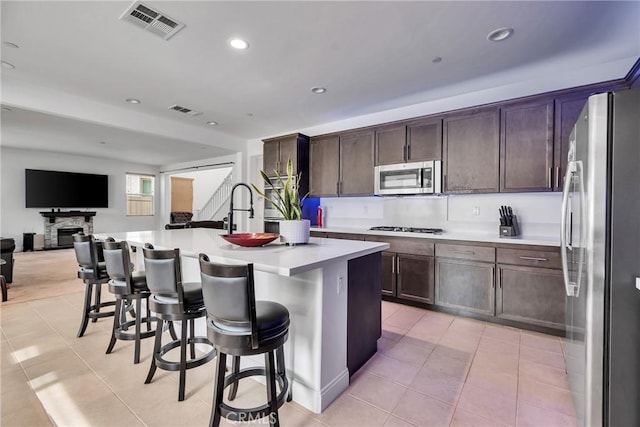 24469 Paxton Ln, Lake Elsinore, CA 92532 - kitchen featuring appliances with stainless steel finishes, light tile patterned flooring, open floor plan, light countertops, and recessed lighting