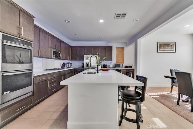 24469 Paxton Ln, Lake Elsinore, CA 92532 - kitchen with appliances with stainless steel finishes, light tile patterned floors, light countertops, dark brown cabinets, and recessed lighting