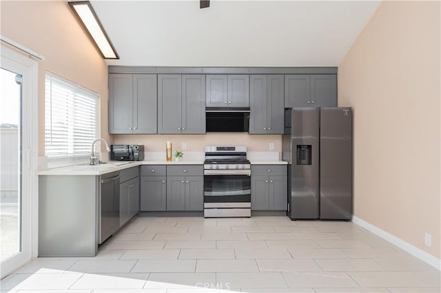 kitchen featuring sink, gray cabinets, stainless steel appliances, and light tile patterned flooring