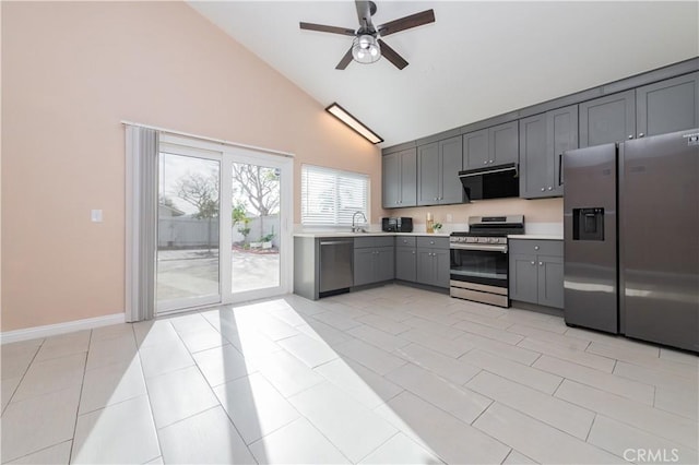 kitchen featuring light tile patterned floors, ceiling fan, appliances with stainless steel finishes, gray cabinetry, and sink