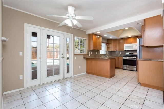 kitchen featuring light tile patterned floors, crown molding, stainless steel gas range, tasteful backsplash, and kitchen peninsula